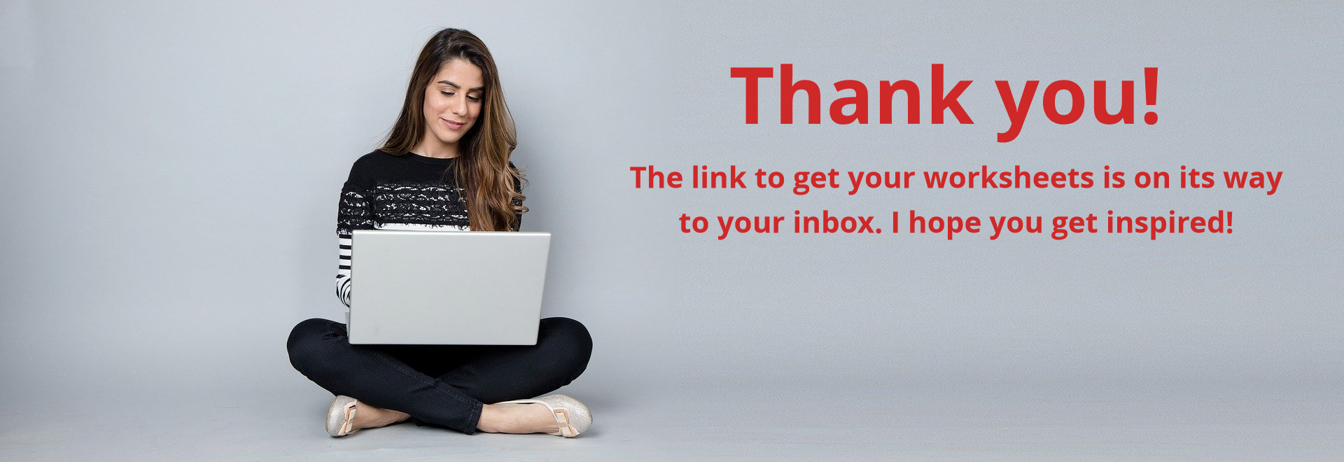 Smiling seated woman looking at laptop computer