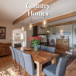 spacious dining room in country home with large dining table surrounded by eight chairs