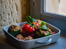 stuffed vegetables in a casserole dish sitting on a counter beside a window