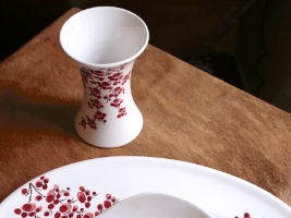white ceramic vase with delicate red blossoms