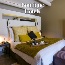 large bed with comfortable pillows and a tea tray in a neutrally decorated room