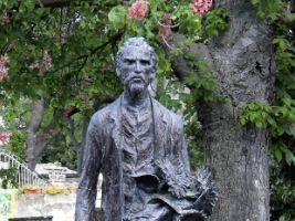 large iron statue of Vincent Van Gogh with trees in the background