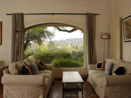 two sofas facing each other with a table between them in front of a window with a beautiful vista