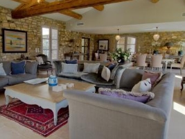 large open living area in with dining area in the background in house with stone walls