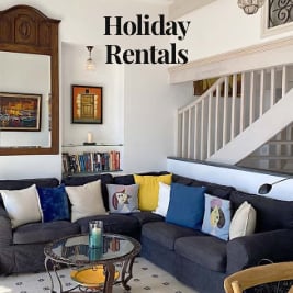 living area with large sectional sofa with book case and stairwell in the background