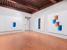 large empty room with large abstract modern paintings hanging on the walls