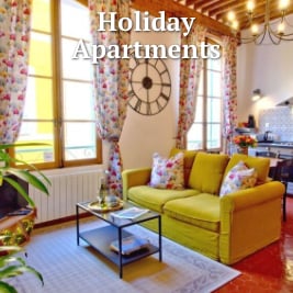apartment living room with yellow sofa and colourful drapes with large clock on the wall