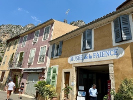 fronts of buildings on town street with cliffs and sky in the background