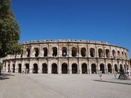 large round building with arches throughout with blue sky in the background