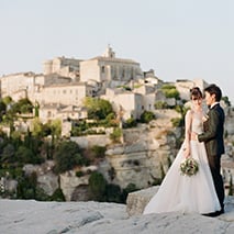 wedding couple kissing with hilltop village in the background