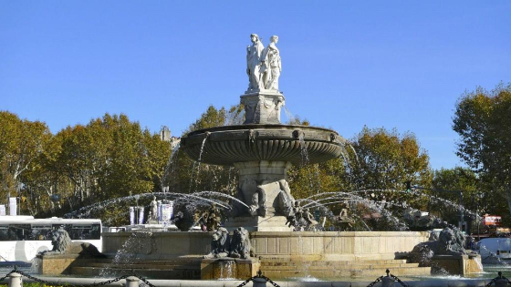 large stone fountain with statues of people on top and lions every 10m around the base