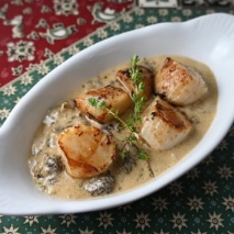 scallops with cream sauce in a white dish