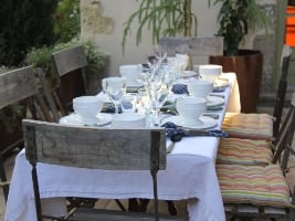 beautifully set table on a patio surrounded by plants