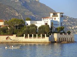 Greek styled mansion surrounded by trees and water