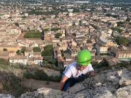 person mountain climbing with view of Cavaillon in background