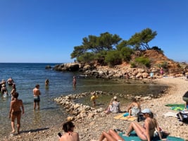 people on a rocky beach and swimming in the sea