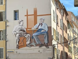 building wall with street art of two French men sitting at a bistro table