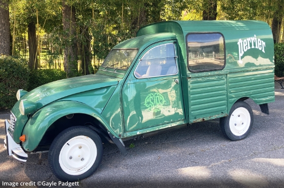 small, green, old fashioned Perrier delivery truck