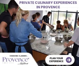 people standing at a counter in a cooking class watching the chef
