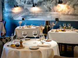 table set with dishes and white tablecloth in elegant restaurant dinign room
