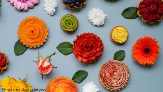 table covered with colourful flowers and pastries shaped like flowers