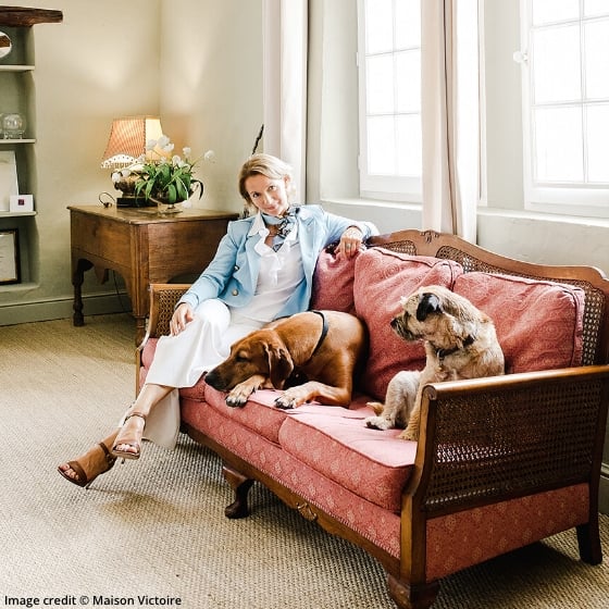 Victoria Templeman sitting on a sofa with two dogs in tastefully decorated living room