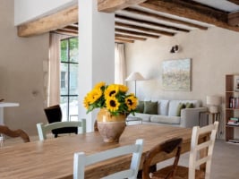 dining table with a vase of sunflowers showing the living area in the background