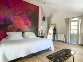 large bedroom with big white bed and a large pink painting with flowers on the wall