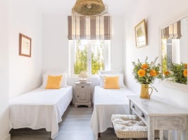 bright cheerful bedroom with two single beds and bright yellow pillows