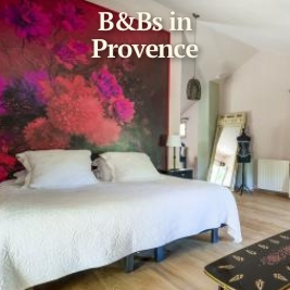 large white bed with brilliant pink flower artwork as headboard