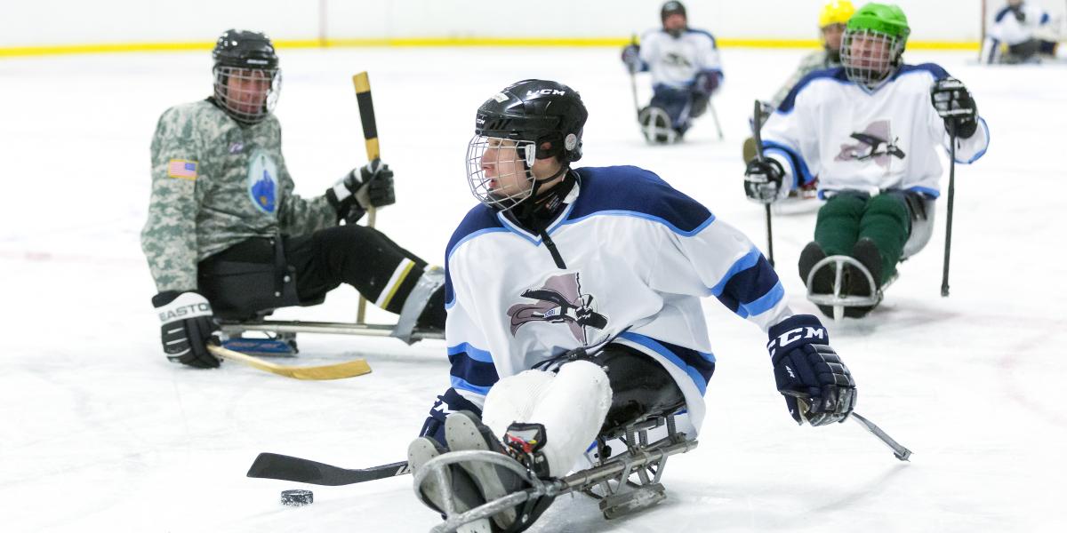 3 people playing adaptive hockey