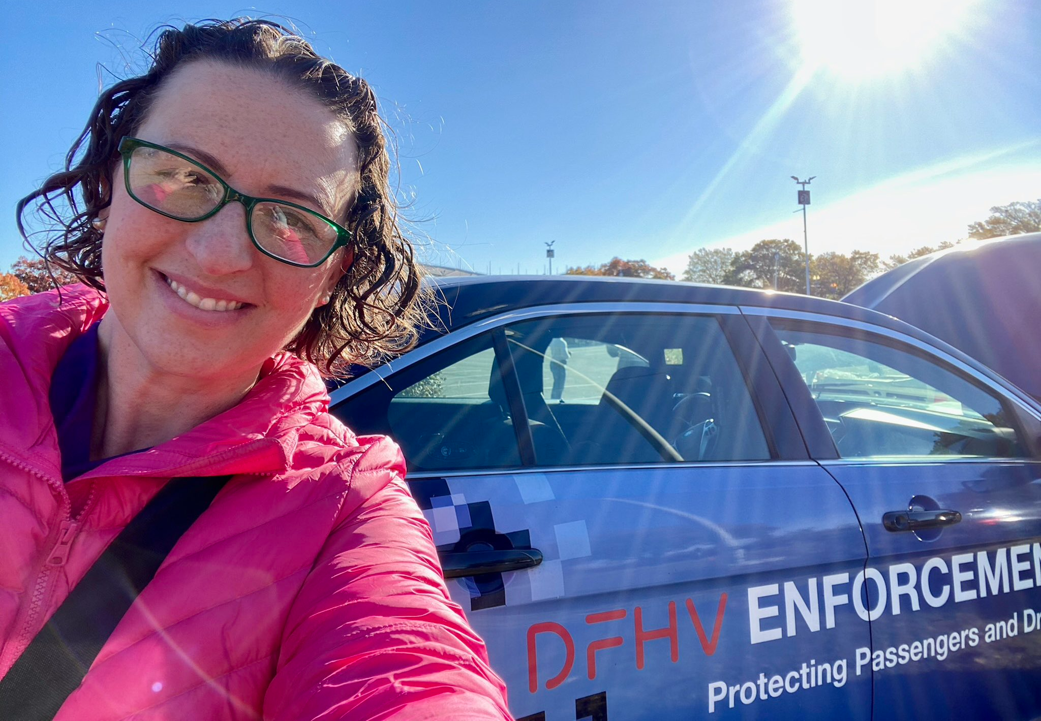 Councilmember Nadeau takes a selfie in front of a Department of For Hire Vehicles enforcement vehicle.