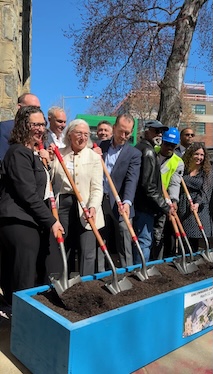 Councilmember Nadeau joins several other individuals with shovels in hand to break ground on dirt in blue container