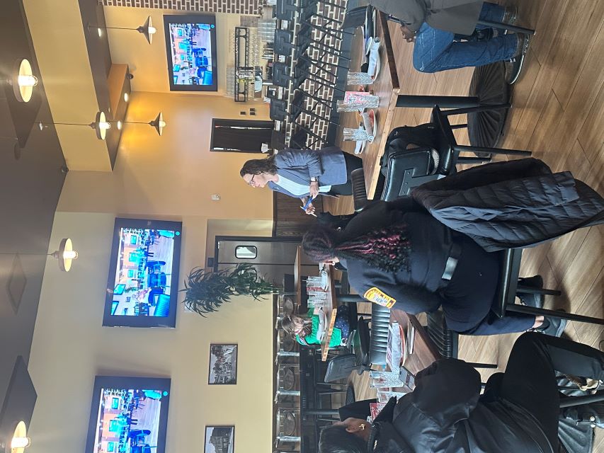 Councilmember Brianne K Nadeau speaks in front of a crowd seated at tables