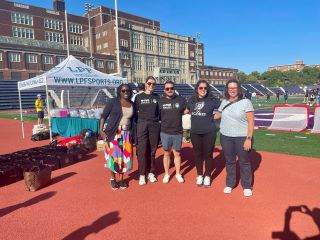 Councilmember Nadeau and DC SCORES staff members pose on track at soccer field