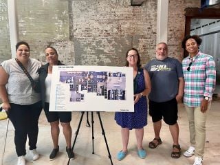 Councilmember Nadeau poses with staff of the LGBTQ+ Center with a map of the new DC Center in the space that is under construction