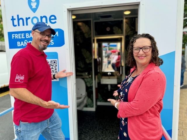 Councilmember Nadeau poses in front of Throne bathroom at Columbia Heights Plaza