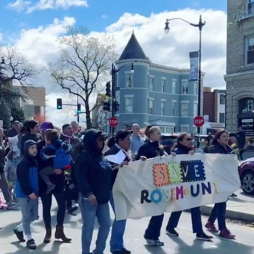 Photo of rally to save Rosemount, people marching and carrying banner that says Save Rosemount