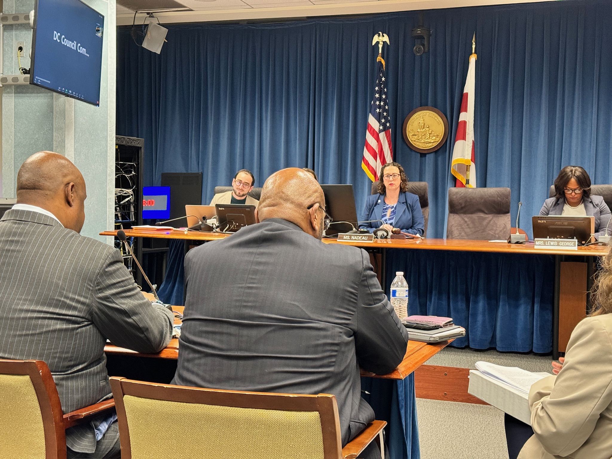 Photo of DC Council hearing with Councilmembers Nadeau and Lewis George seated on the dais and DPW Director Spriggs at the witness table