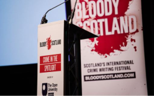A lectern bearing the logos for Bloody Scotland and The Open University in Scotland