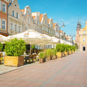Street scene in Europe showing restaurants with large, branded, commercial-grade parasols.