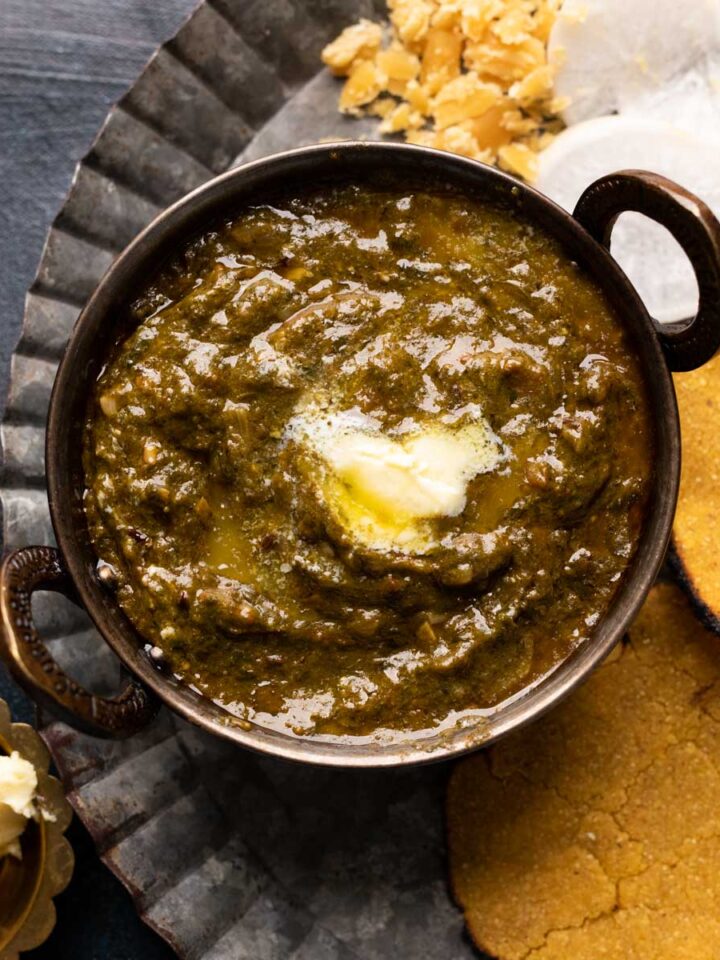 A bowl of chunky saag gravy with a dollop of white butter
